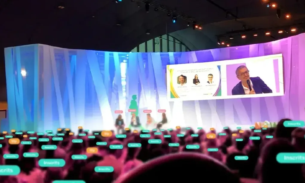 A plenary session in front of a full room, speakers on stage